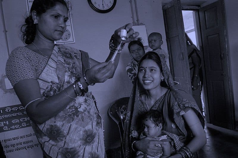 Community health worker giving a vaccination in India
